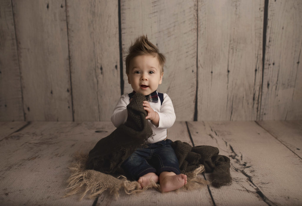 Little boy with awesome hair posing for his seven month milestone session.