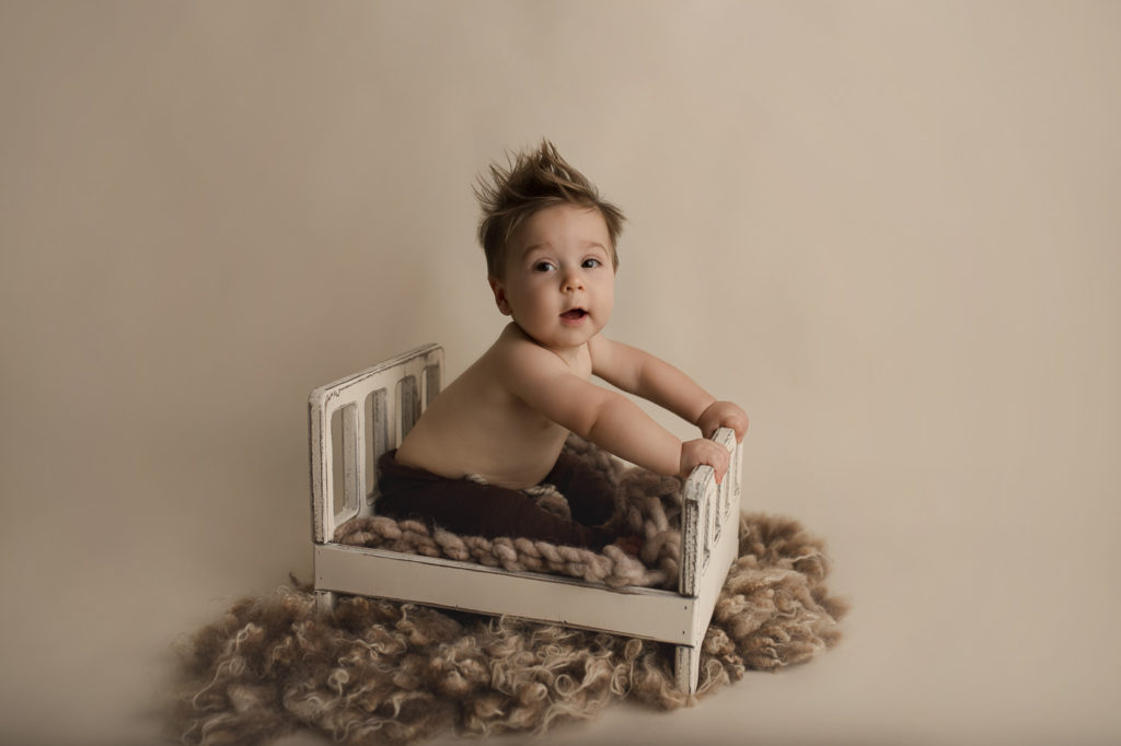 Posing on a little bed at his Indiana milestone session.