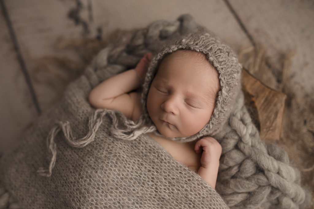 Cute baby boy in a light grey setup for his newborn session in Indiana.