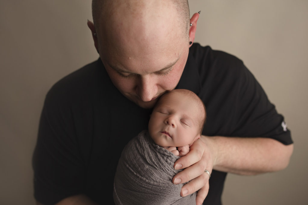 Dad holding baby boy at their Indianapolis newborn session.
