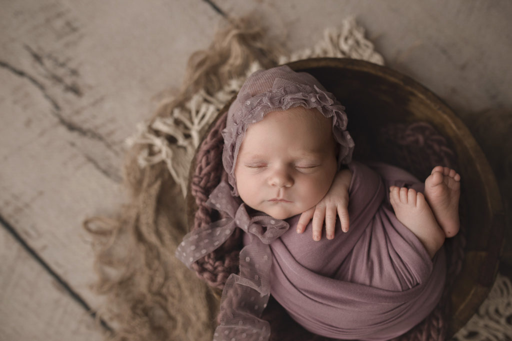 Newborn baby girl styled in purple for her newborn session.