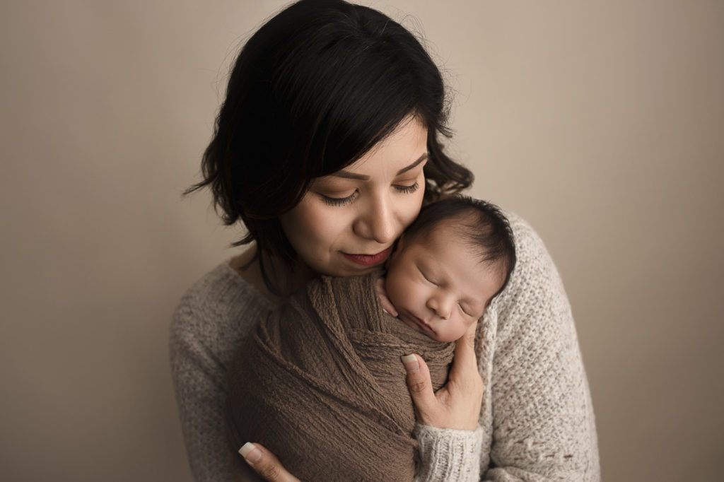 Mom sweetly holding her new baby boy during newborn session.