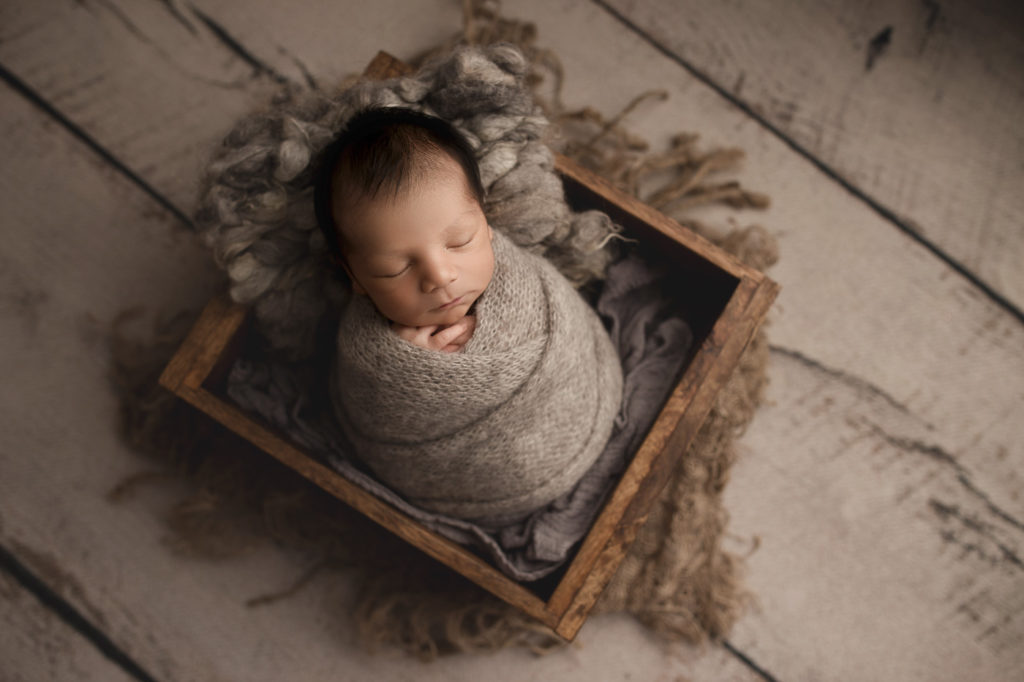 Posed baby boy in a crate at his Lafayette newborn session.