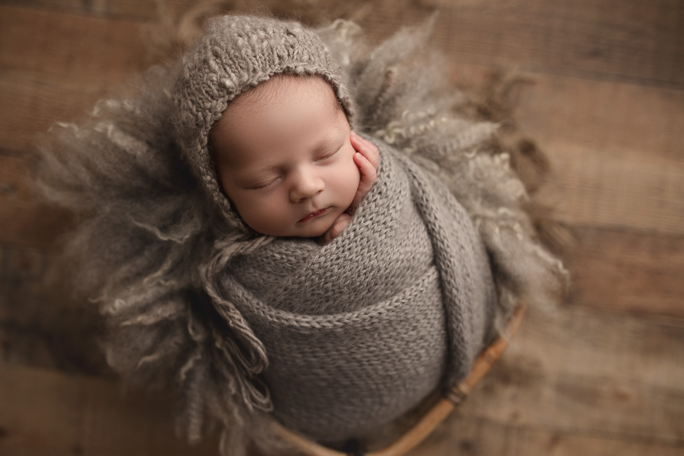 Baby boy posed in a cute rustic crate at his studio newborn session.