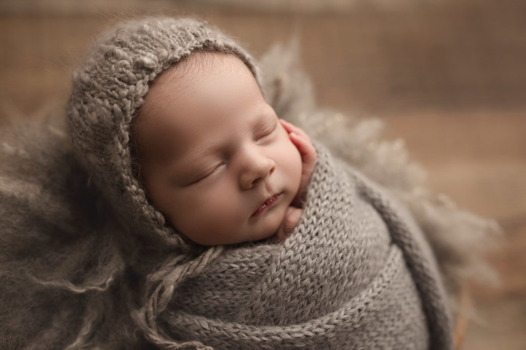 Sweet baby boy posed in a light grey setup at his Lafayette studio newborn session.