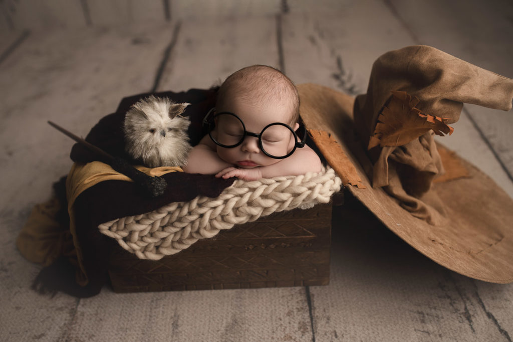 Cute baby boy posed with Harry Potter props during a Lafayette Indiana newborn session.