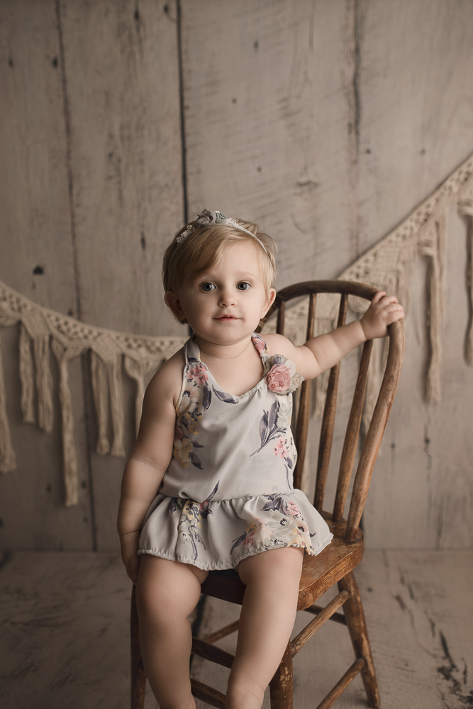 Sweet girl wearing a floral romper at her milestone session.