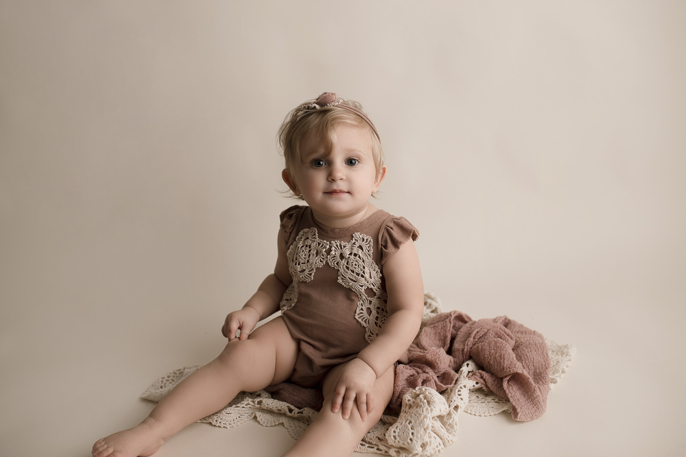 Adorable baby girl in a pink outfit at her milestone session in Lafayette.
