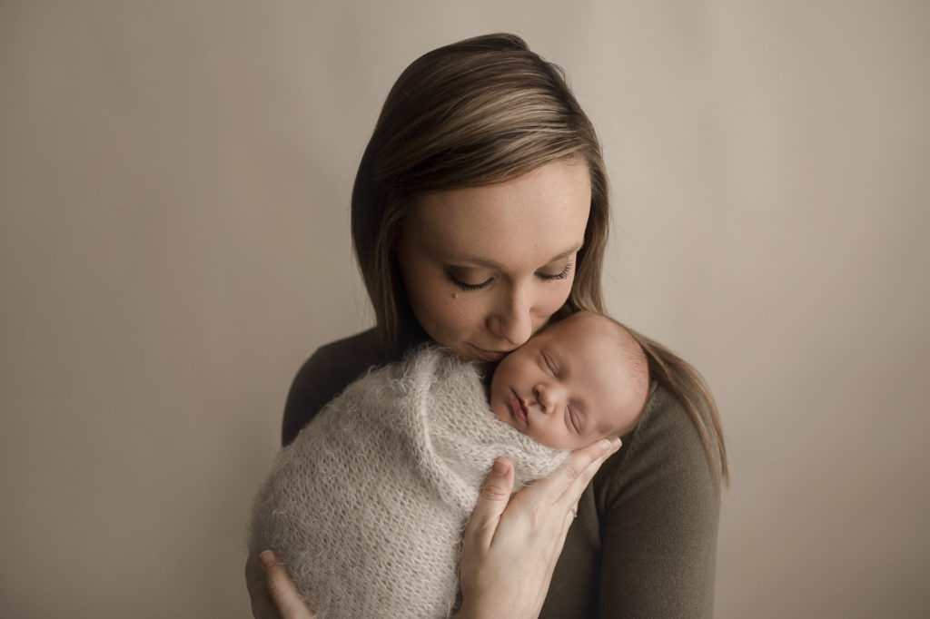 Mom giving her son kisses during their Lafayette Indiana studio newborn session.