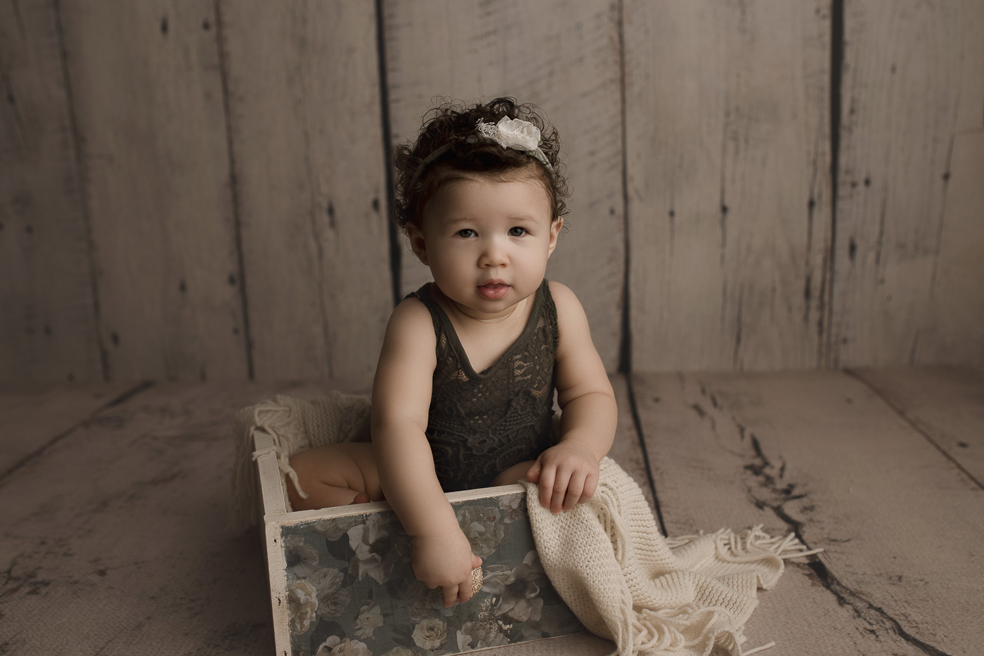 Little girl in a floral crate having fun at her milestone session in Lafayette Indiana.