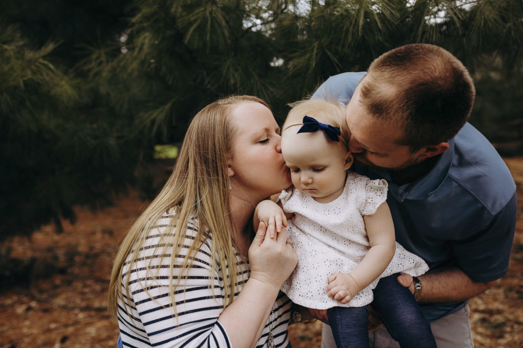Sweet kisses at their daughter's one year photography session in Indiana.