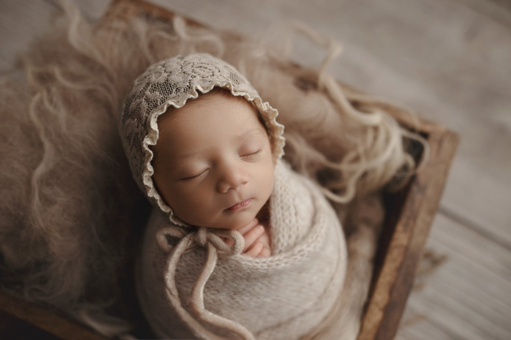 Peaceful baby girl wearing a lace bonnet at her Lafayette Indiana studio session.