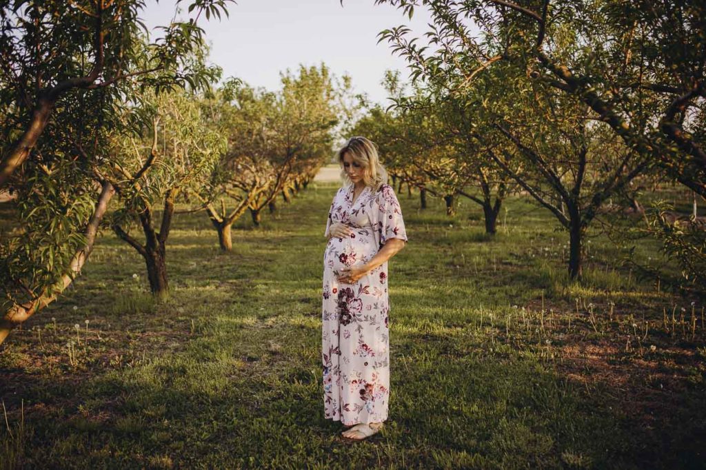 Mom posed during her maternity session in the orchard.