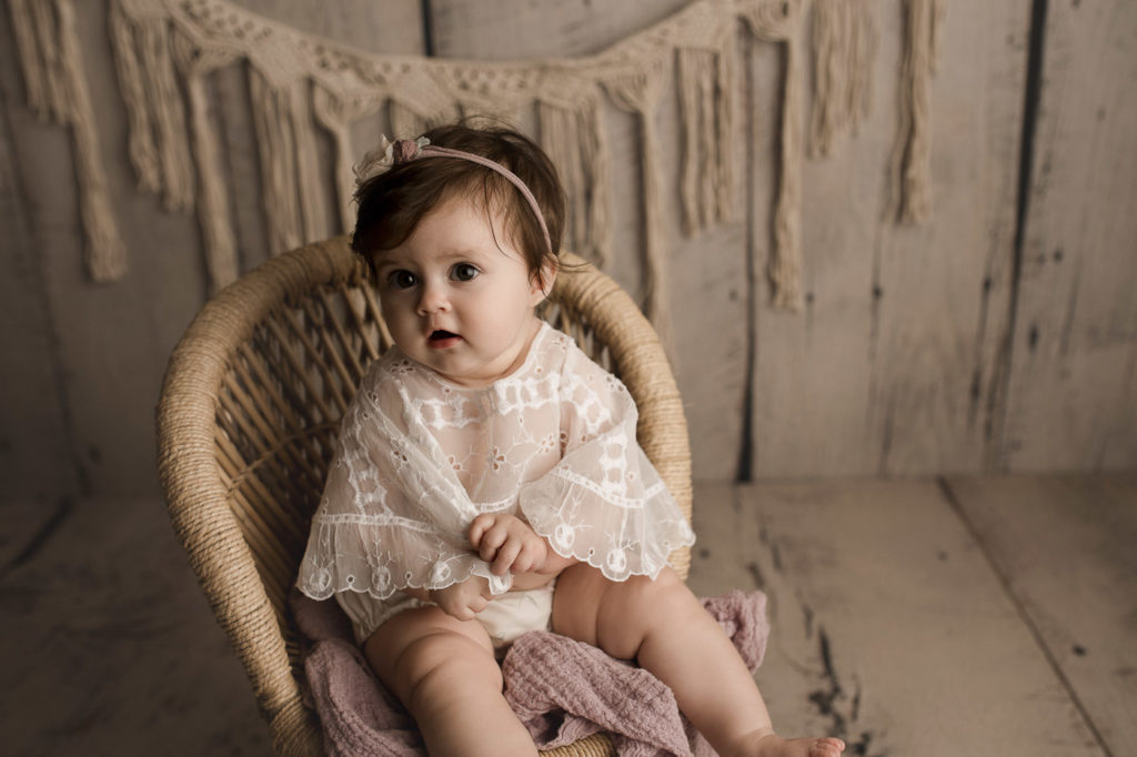A little girl wearing a cute cream outfit for her milestone session.
