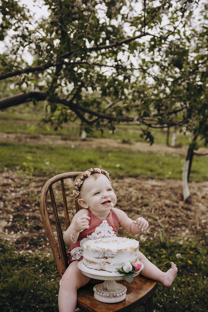 Sweet little girl eating her cake at her first birthday photography session in Indiana.