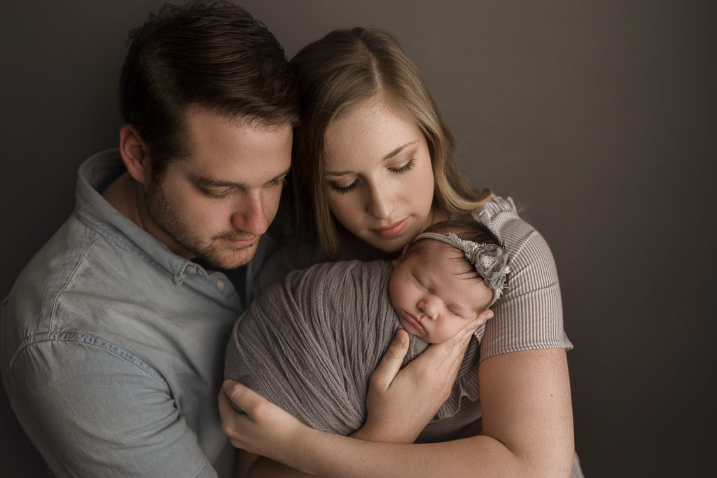 Family posed during newborn session for baby girl.