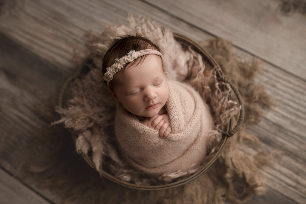 Baby girl in a rustic basket in Lafayette Indiana.