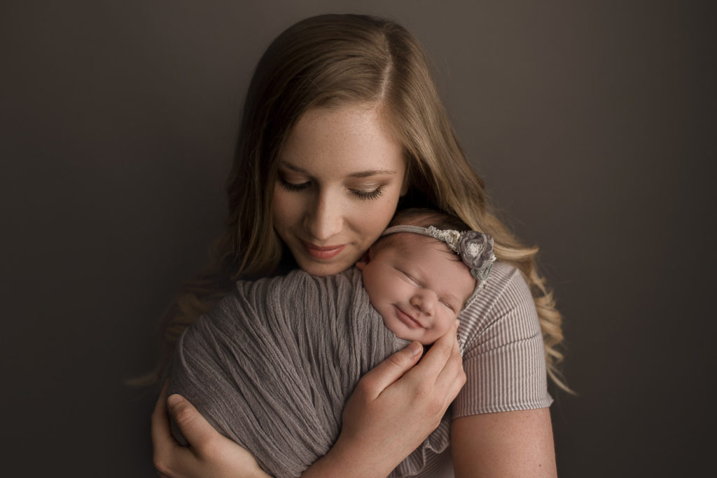 Mom holding baby girl during newborn session in Lafayette and Peru Indiana.