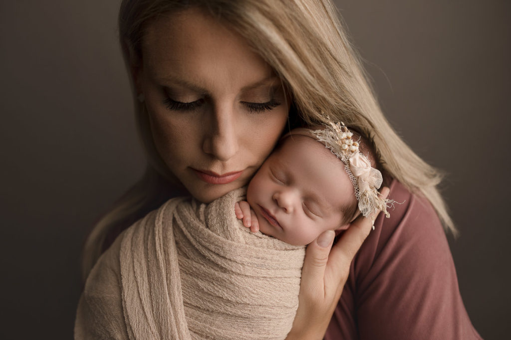 Gorgeous mom during Indiana newborn session holding baby girl.