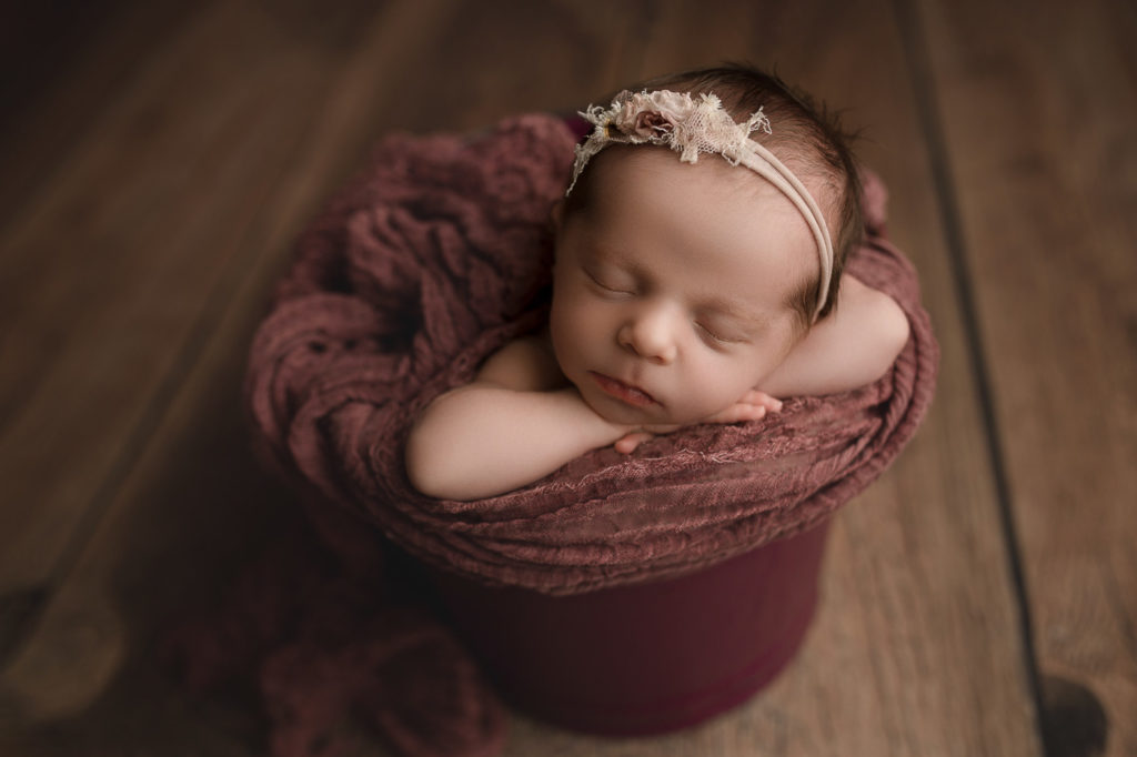 Lovely baby girl posed in a bucket.