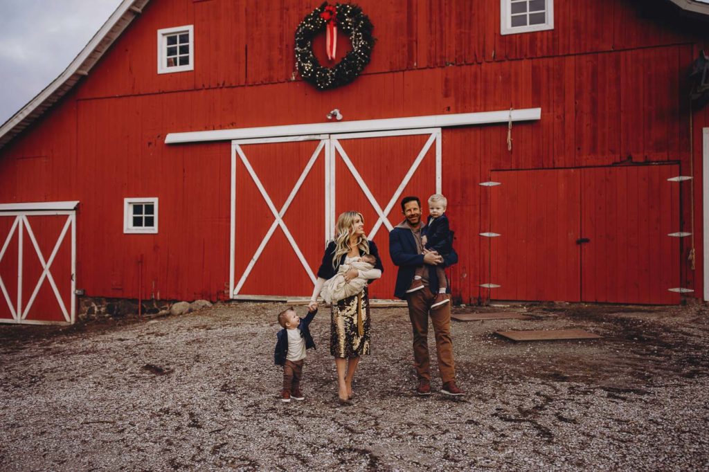 Family posed in front of a red barn in Indiana.